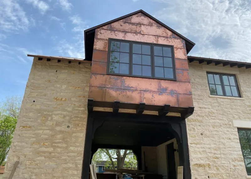 Copper metal panel facade on a stone building for Roof Repair in Country Club